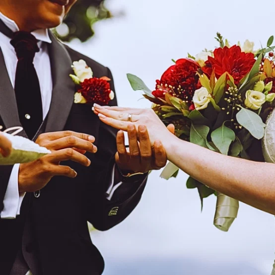 a bride placing a wedding ring on the groom's finger during a ceremony. Get Married While on a Student or Work Visa