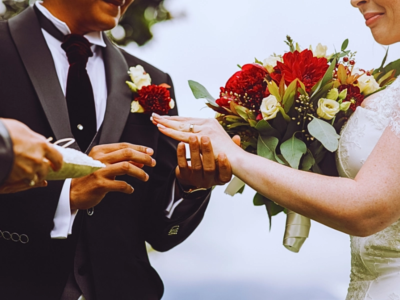 What Happens If You Get Married While on a Student or Work Visa? 1 a bride placing a wedding ring on the groom's finger during a ceremony. Get Married While on a Student or Work Visa
